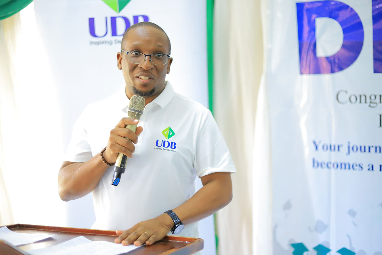 Joshua Allan Mwesiga, Director Strategy and Corporate Affairs at UDB speaks during the graduation ceremony in Mbarara